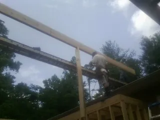 Carpenter setting a ridge beam over a new addition frame — Ice Dam Removal by Roofing Brothers in Chula Vista