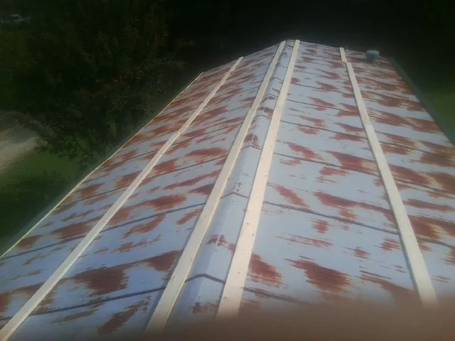 Rusted metal roof panels with new wood purlins before replacement — Storm Damage Roof Repair in Chula Vista by Roofing Brothers