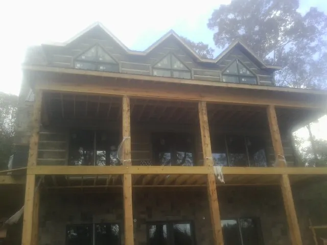 Dormers and porch framing on a large log home under construction — Roof Coating work by our crew in Chula Vista